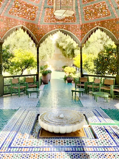 Le Jardin Secret pavilion with intricate tilework and lush greenery in Marrakech, Morocco.