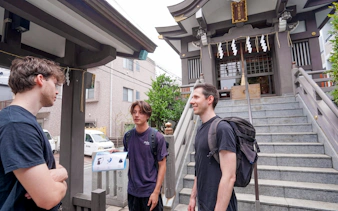 Visitors discussing outside a Tokyo shrine during a Samurai experience tour.