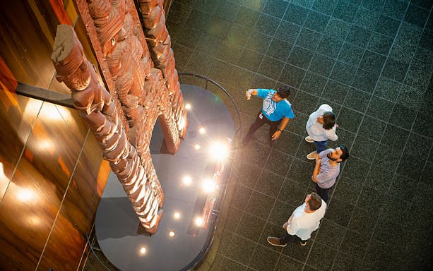 Visitors viewing a carved wooden structure at Te Papa Tongarewa Museum's Gallipoli Exhibition.