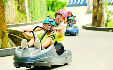Mother and child riding a luge at Hanuman Luge, enjoying the downhill track.