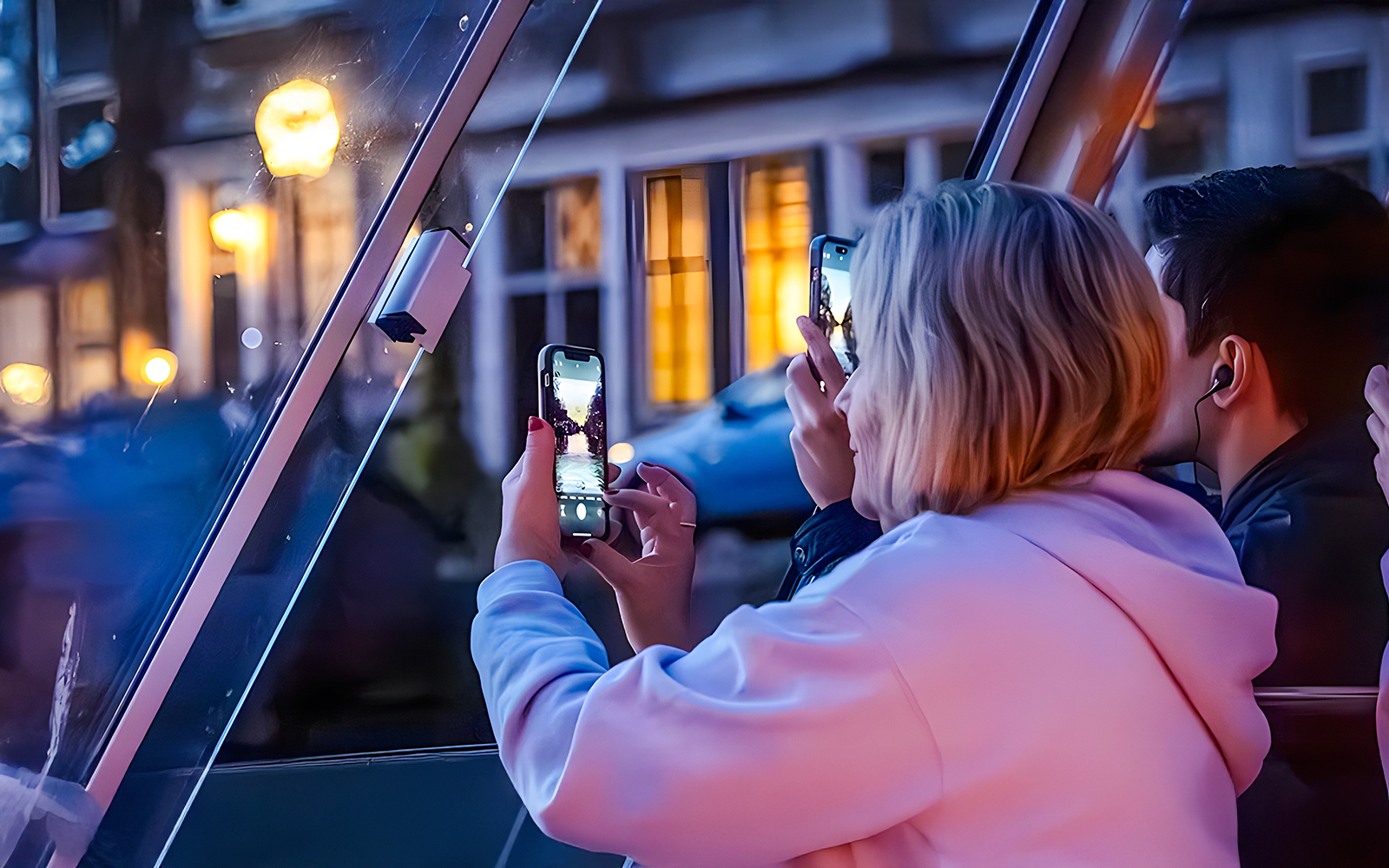 People taking photos through a boat window during the Happy Holidays Evening Cruise.