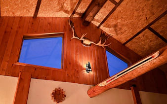 Interior of Aurora Borealis Viewing Lodge with wooden walls and antler decor, Alaska.
