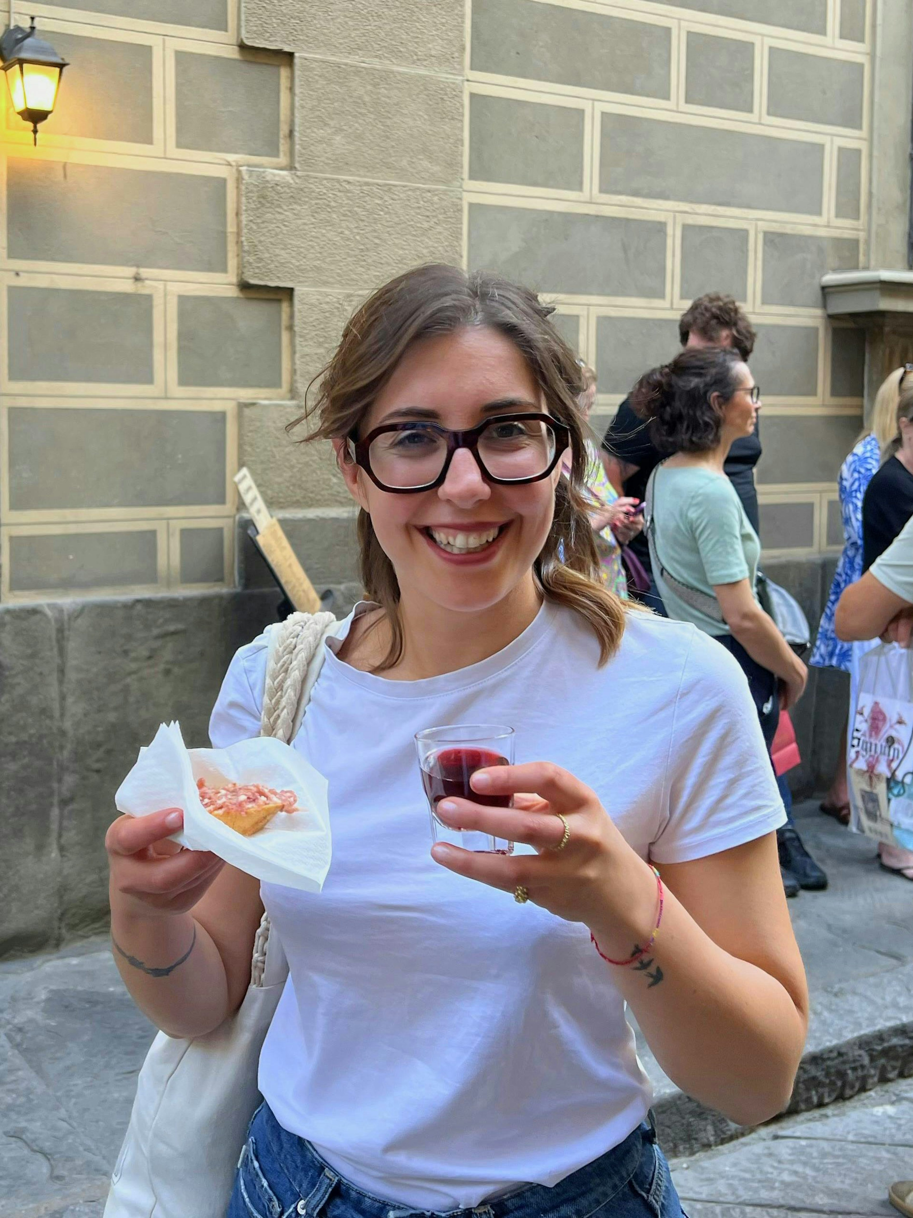 Tourist enjoying wine and local food on a Florence food tour.
