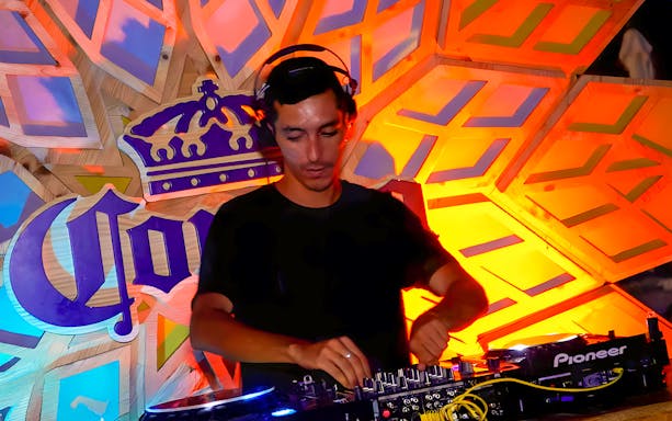 DJ performing at night event in Siam Park, vibrant lights and crowd enjoying music.