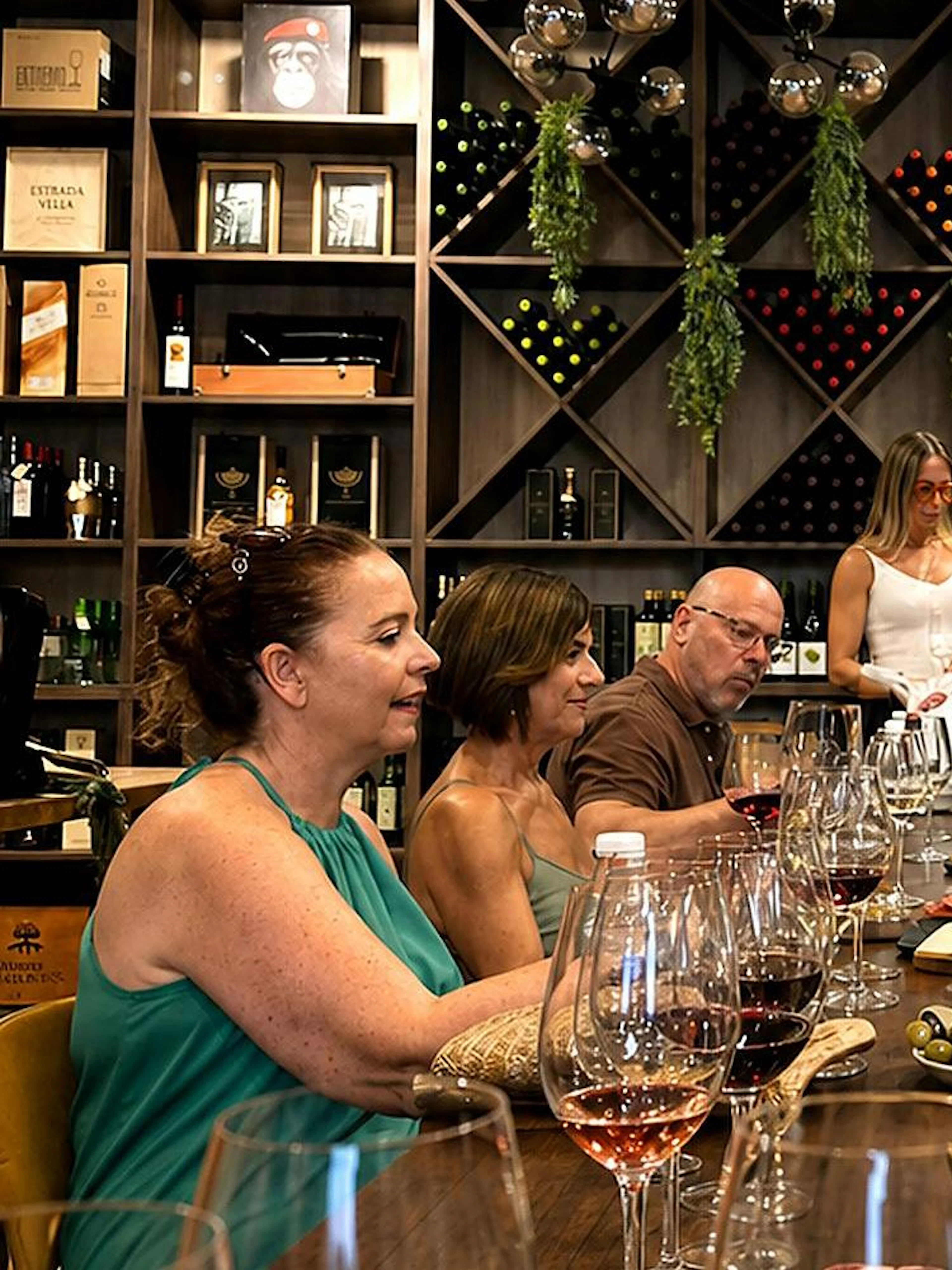 Group enjoying wine tasting with tapas in Málaga wine cellar.