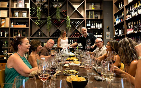 Group enjoying wine tasting with tapas in Málaga wine cellar.