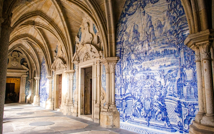 Interior of Igreja do Carmo in Portugal with blue tile murals and arched ceilings.