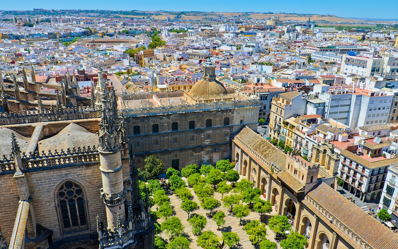 View from La Giralda tower overlooking Seville's historic architecture and cityscape.