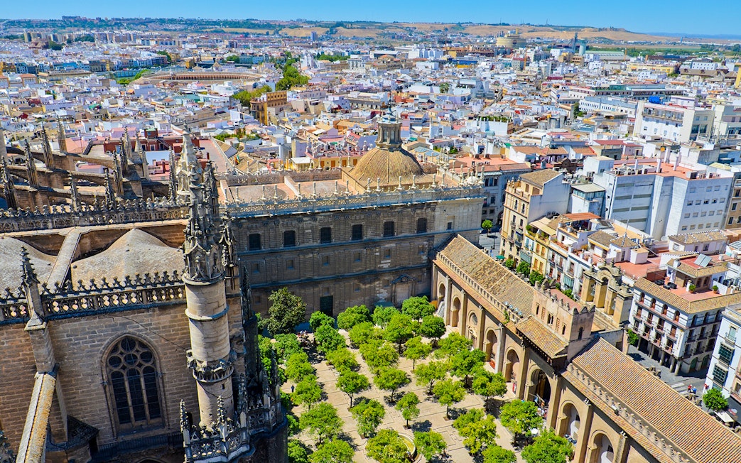 View from La Giralda tower overlooking Seville's historic architecture and cityscape.