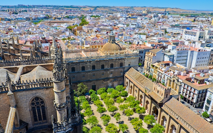 View from La Giralda tower overlooking Seville's historic architecture and cityscape.