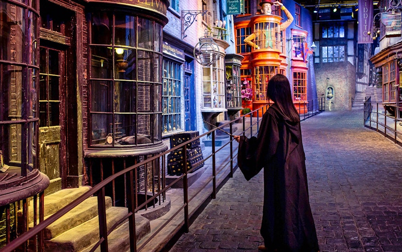 Visitor in wizard robe exploring Diagon Alley set at Warner Bros. The Making of Harry Potter Studio Tour.