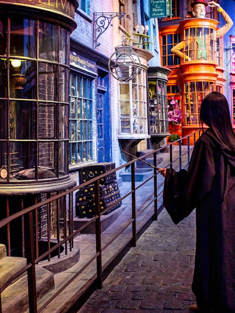Visitor in wizard robe exploring Diagon Alley set at Warner Bros. The Making of Harry Potter Studio Tour.