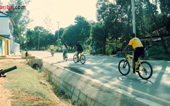 Cyclists on a village road during a bike tour, Diani Beach.