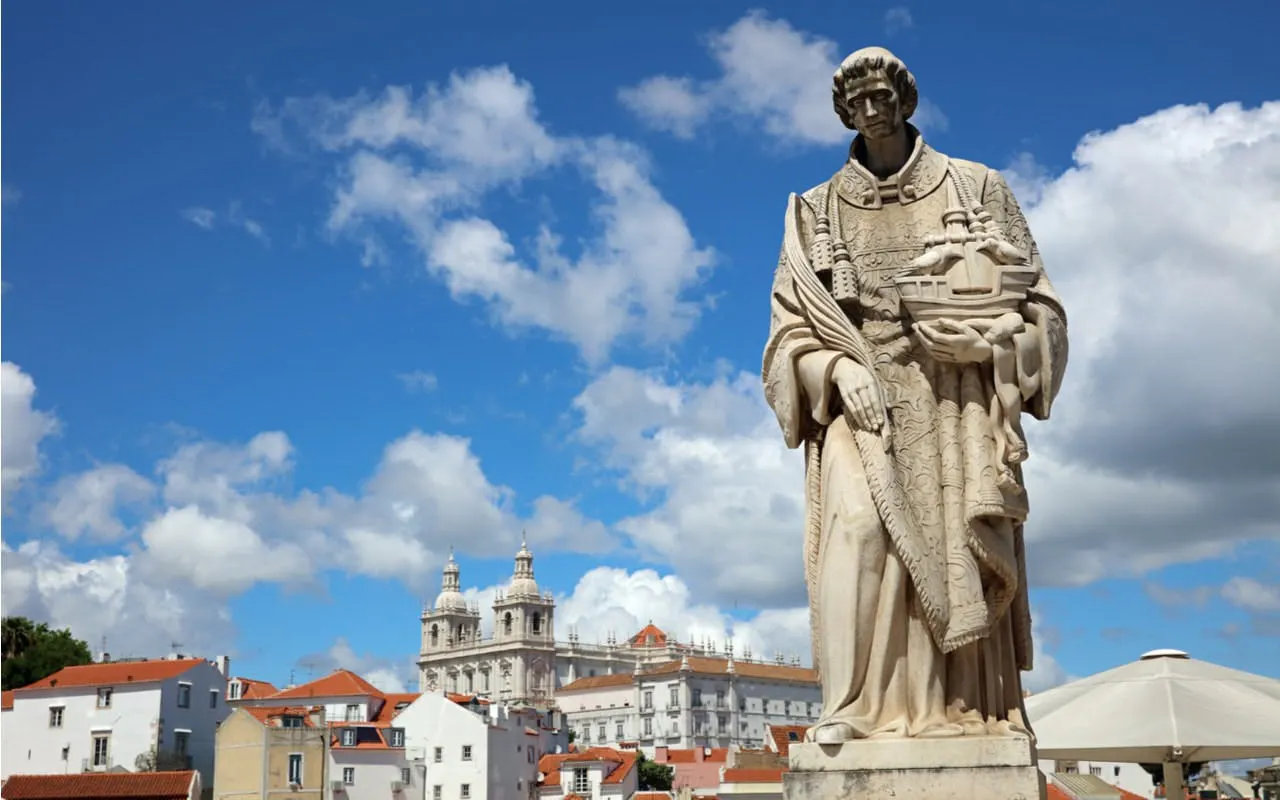Statue in Lisbon with São Vicente de Fora Monastery in the background.
