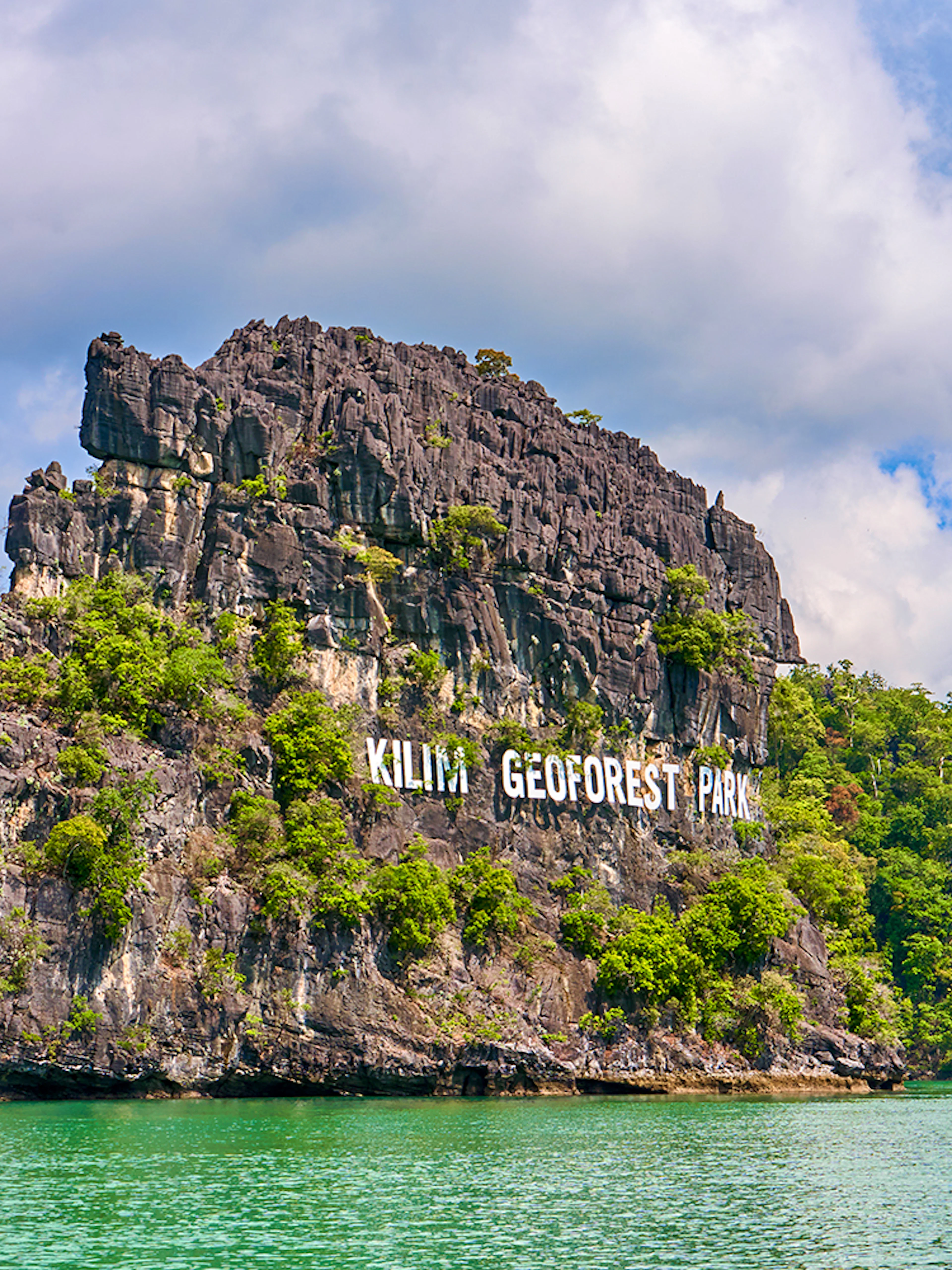 Kilim Geoforest Park sign on rocky hill, Langkawi, Malaysia.