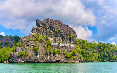 Kilim Geoforest Park sign on rocky hill, Langkawi, Malaysia.