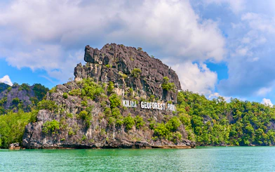 Kilim Geoforest Park sign on rocky hill, Langkawi, Malaysia.
