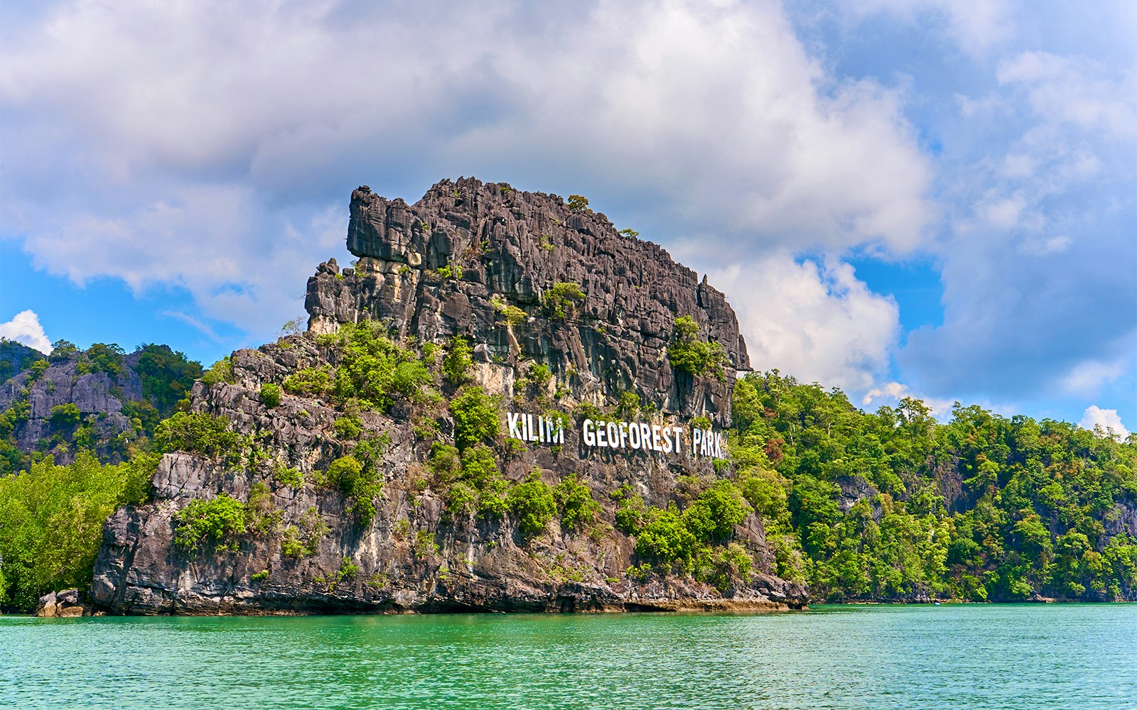 Kilim Geoforest Park sign on rocky cliff, Langkawi, Malaysia.