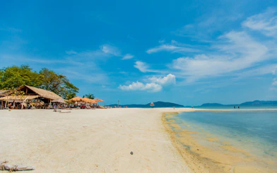 White sand beach with huts and clear water at Koh Samui Pig Island.