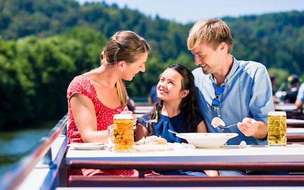 Family enjoying lunch on a Koblenz river cruise with scenic views.