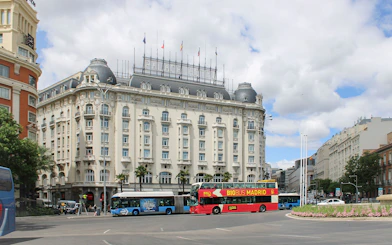 Big Bus Madrid tour passing by the historic Palace Hotel in Madrid.