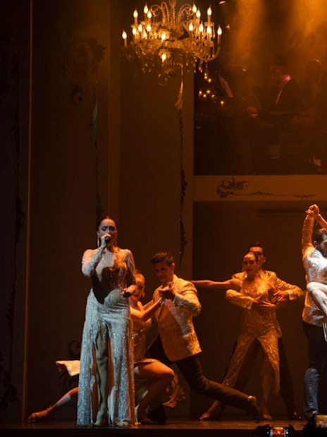 Tango dancers performing at Café de los Angelitos with live musicians in Buenos Aires.