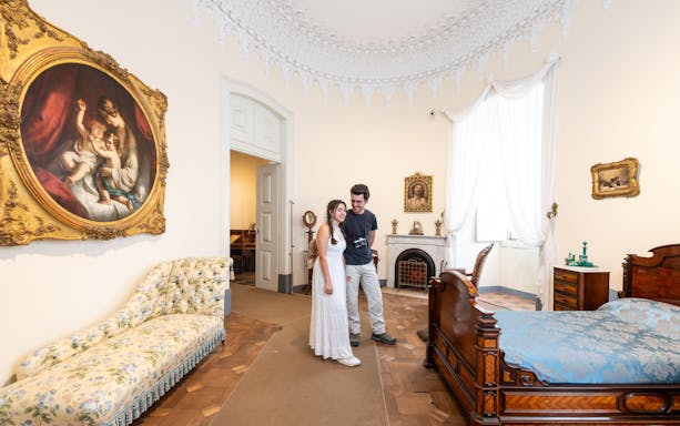 Tourist with guide in the Queen's bedroom of Pena Palace, Sintra, Portugal.