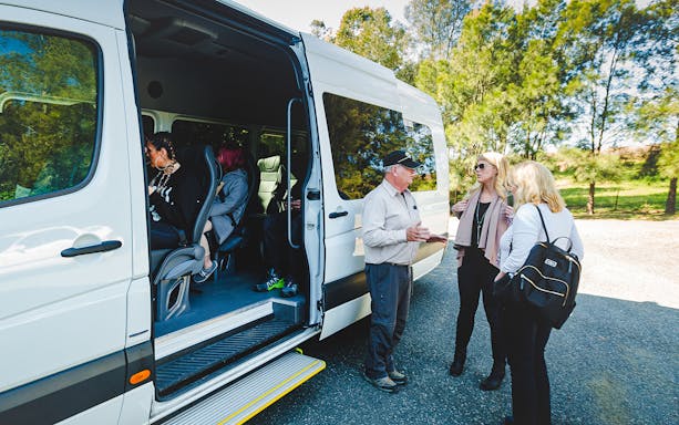 Luxury coach pickup for Blue Mountains guided tour with passengers boarding.