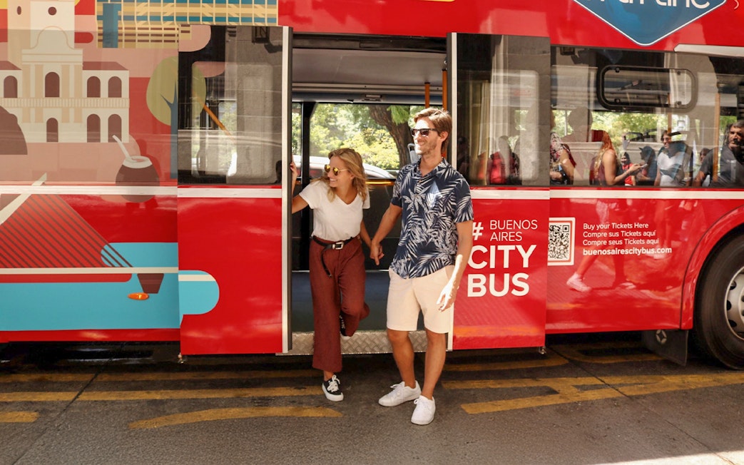 Couple exiting Buenos Aires hop-on hop-off City Bus Gray Line.