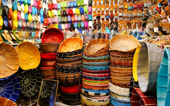 Colorful leather goods and slippers displayed in Marrakech souk.