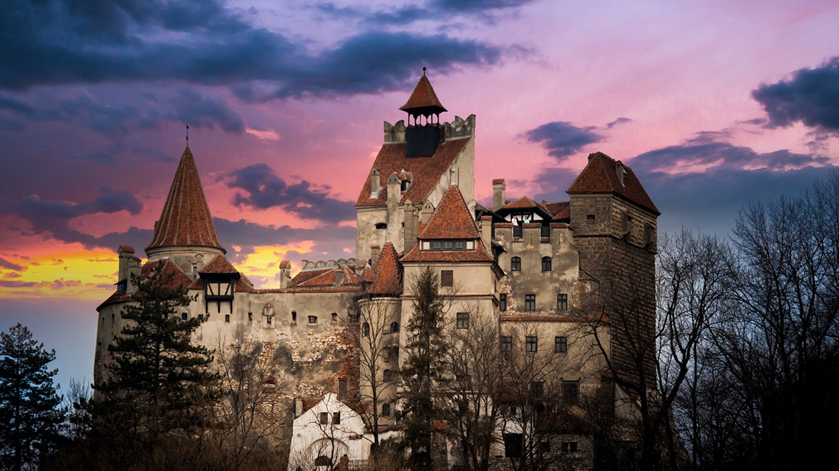 Bran Castle at sunset with dramatic sky, Transylvania, Romania.