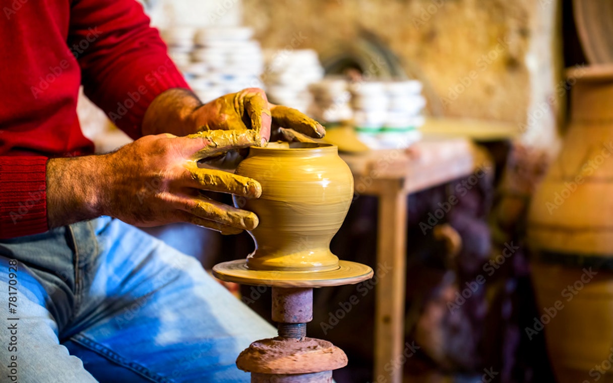 Potter shaping clay on a wheel in Avanos workshop.