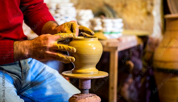 Potter shaping clay on a wheel in Avanos workshop.