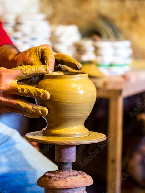 Potter shaping clay on a wheel in Avanos workshop.