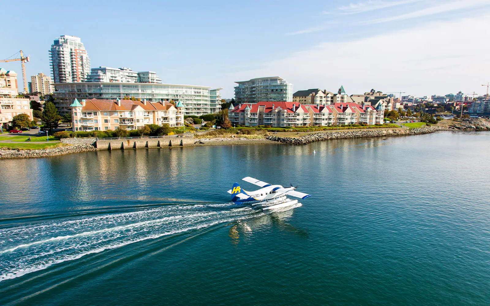 Seaplane landing on water near Victoria waterfront buildings, Victoria Panorama Seaplane Scenic Tour.