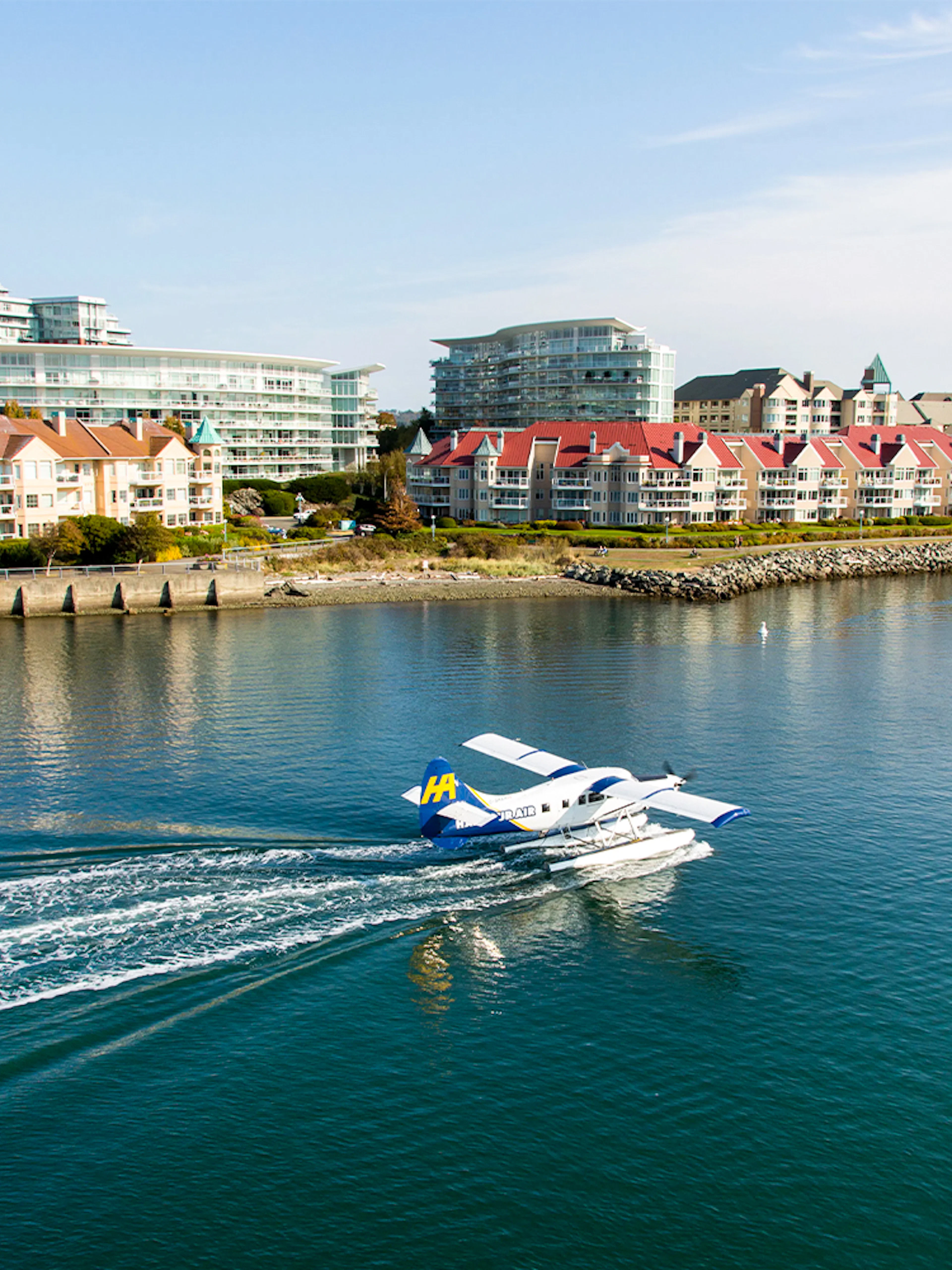 Seaplane landing on water near Victoria waterfront buildings, Victoria Panorama Seaplane Scenic Tour.