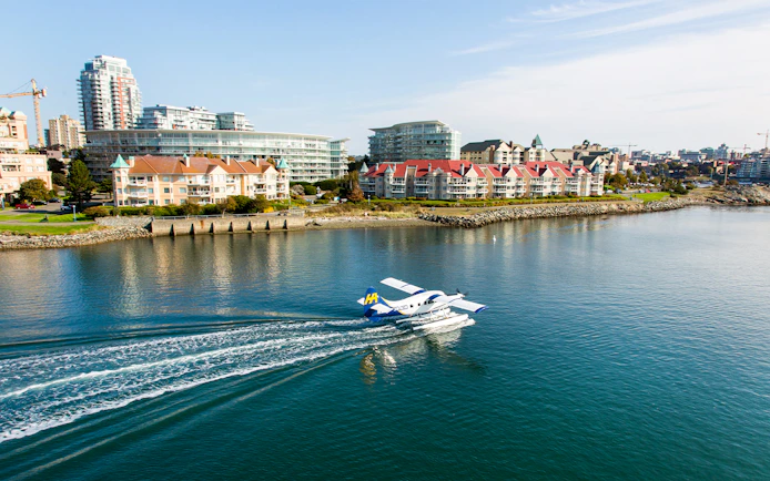 Seaplane landing on water near Victoria waterfront buildings, Victoria Panorama Seaplane Scenic Tour.