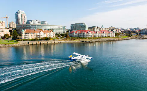 Seaplane landing on water near Victoria waterfront buildings, Victoria Panorama Seaplane Scenic Tour.