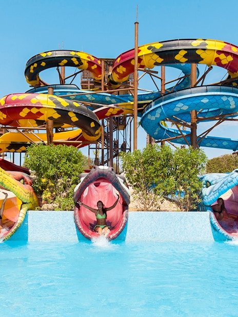 Anaconda water slide at Aqualand El Arenal with colorful snake-themed tubes.