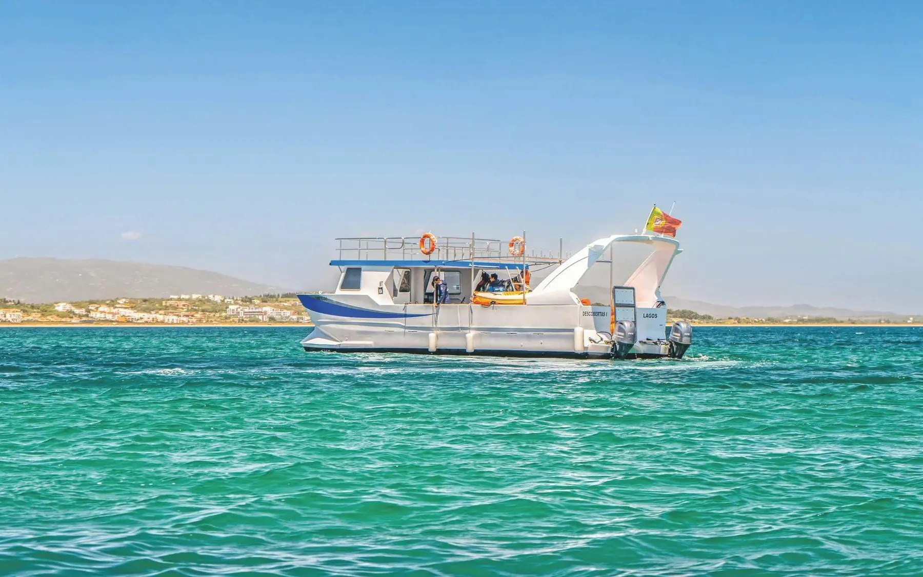 Boat on turquoise waters during Ponta da Piedade Algarve kayak tour.