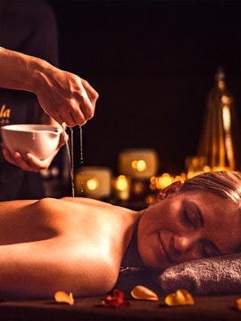 Relaxing oil massage at Mandala Day Spa with candles in the background.