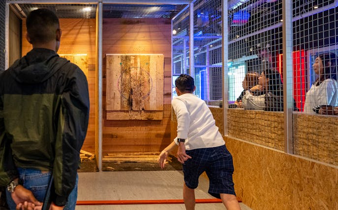 Man throwing axe at target in Axe Factor, Sentosa.