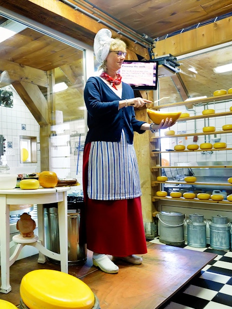Dutch cheese maker demonstrating cheese production on a guided tour.