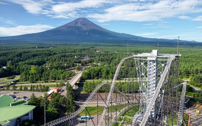 Roller coaster at Fuji-Q Highland Amusement Park with Mount Fuji in the background.