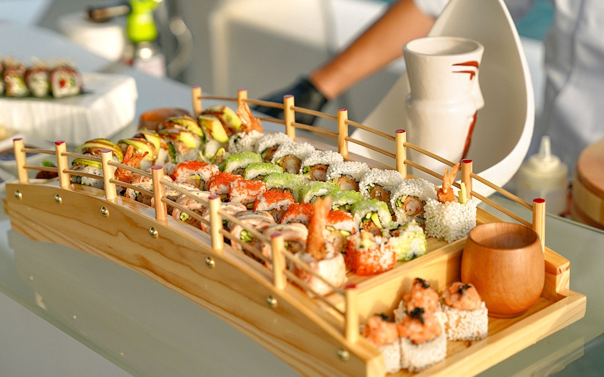 Sushi platter on Sunseeker superyacht with gourmet dining setup.