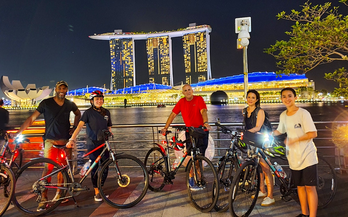 Group cycling at night by Marina Bay Sands, Singapore.