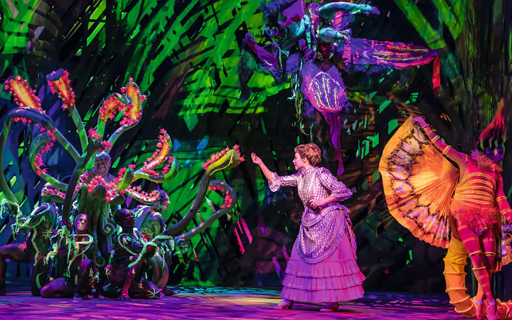 Performer in jungle-themed costume on stage during Disney's Tarzan show.