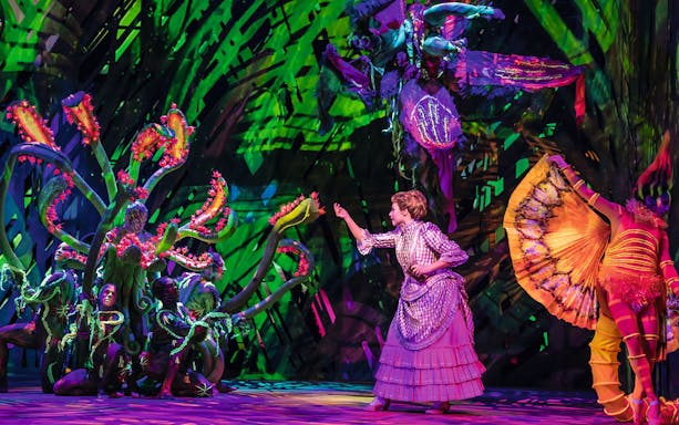 Performer in jungle-themed costume on stage during Disney's Tarzan show.