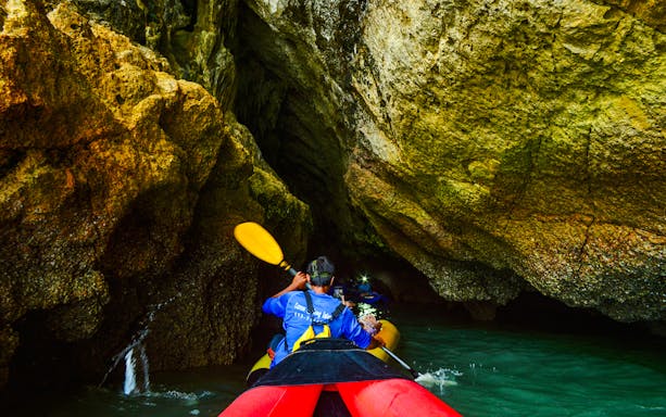 Tourists kayaking near limestone cliffs at James Bond Island, Phang Nga Bay, Thailand.