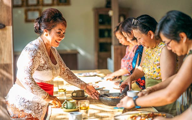 Cooking class participants preparing dishes at Paon Bali in Ubud.